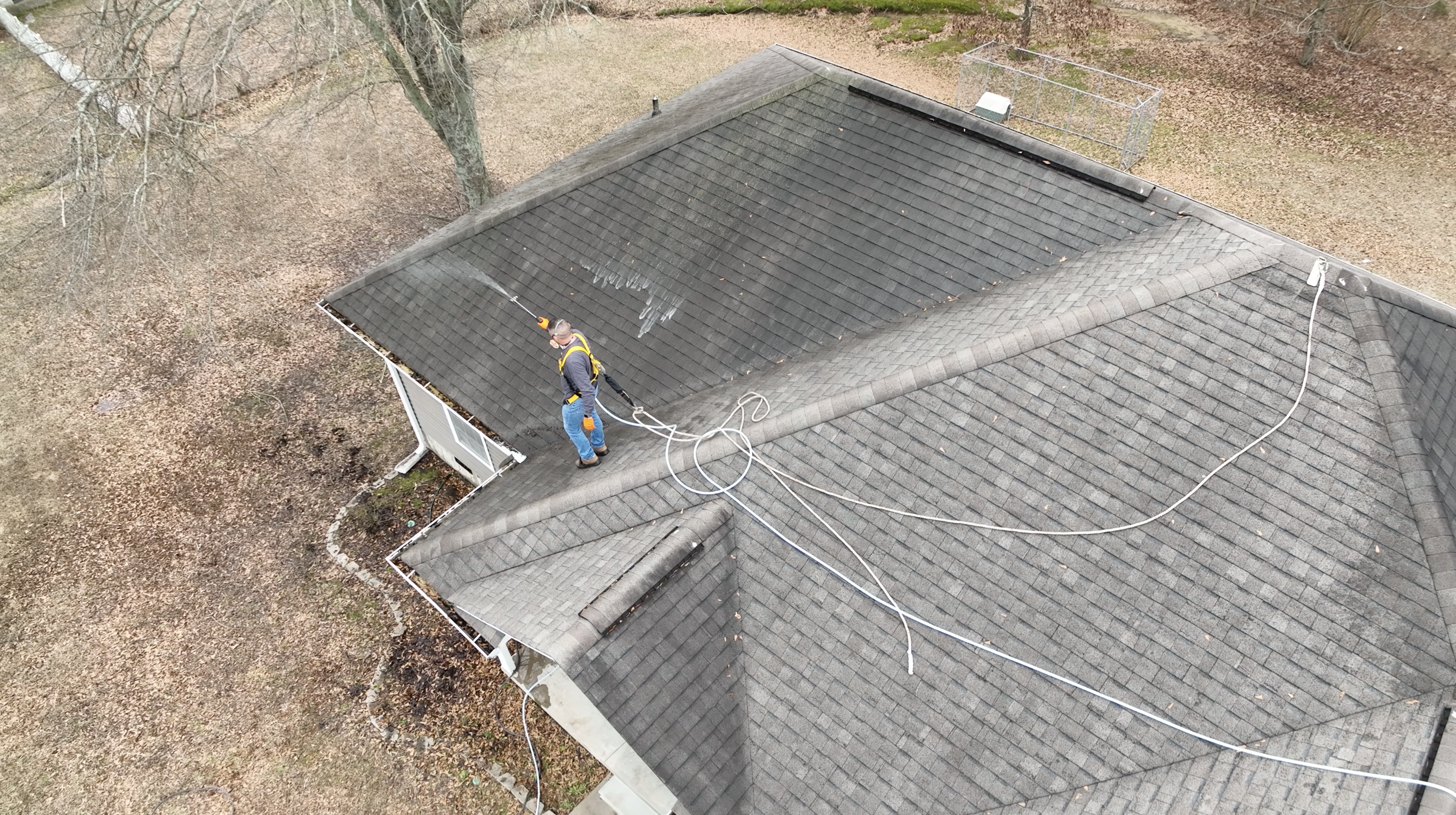 Certified Roof Shield Applicator soft washing a roof before restoring it with Roof Reboot by Roof Shield.