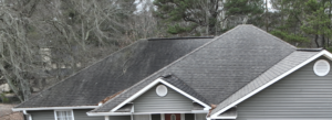 Unsightly black streaks, aka Gloecapsa Magma, on a roof before treatment by Roof Shield.