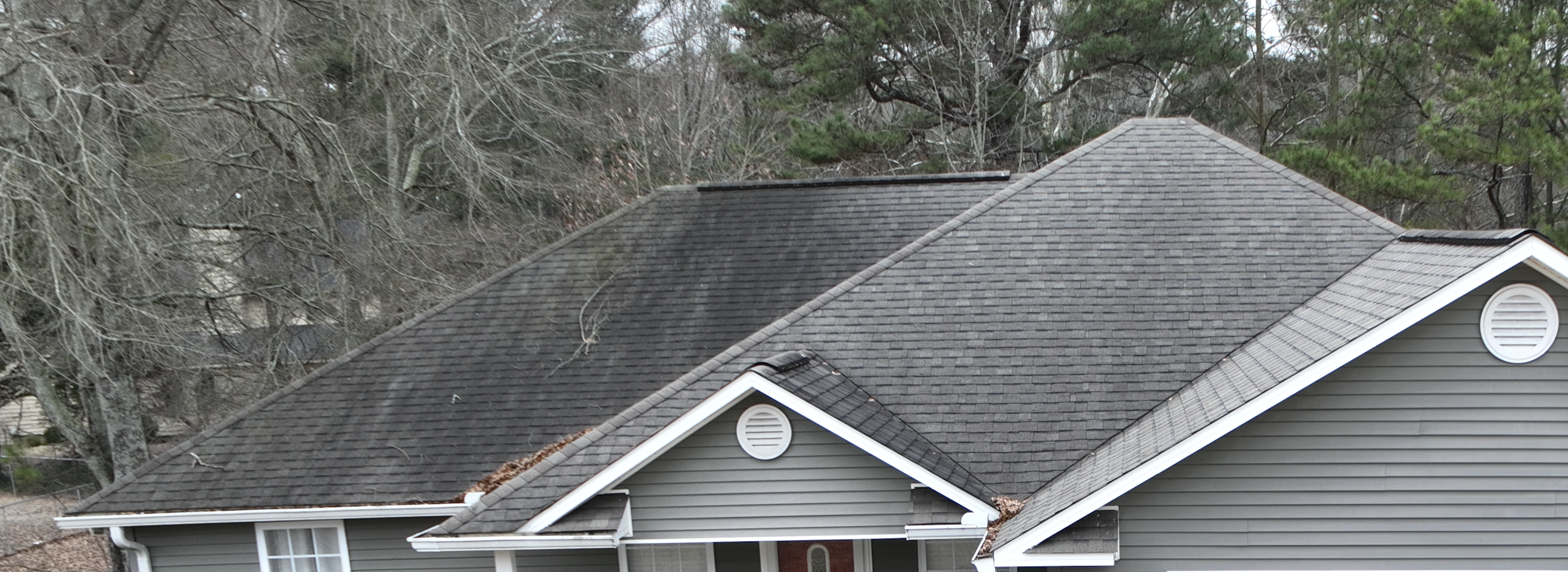 Unsightly black streaks, aka Gloecapsa Magma, on a roof before treatment by Roof Shield.
