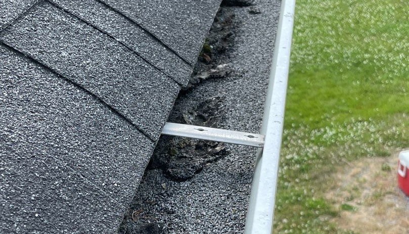 Asphalt shingle granules collect in the gutters around the house during degranulation and granule loss. The granules reduce the capacity of the gutters and make clogs more likely.