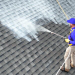 Roof Shield applicator spraying the asphalt shingle rejuvenator, Roof Reboot, on a client's roof.