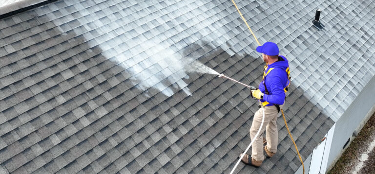 Roof Shield applicator spraying the asphalt shingle rejuvenator, Roof Reboot, on a client's roof.